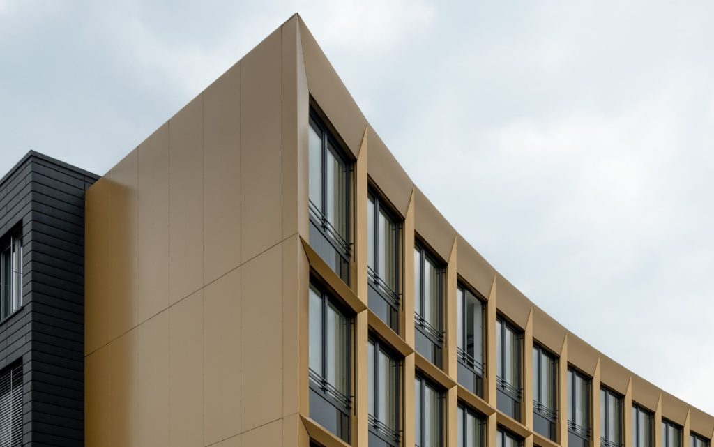 Modernes Bürogebäude mit gelber Fassade und zahlreichen Fenstern